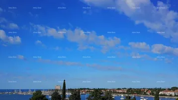 Panoramablick auf den Hafen, das Meer und die Küstenstadt unter blauem Himmel mit Wolken.
