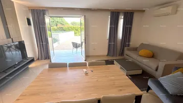 Helles Wohn- und Esszimmer mit modernem Esstisch, Sofa und direktem Zugang zur Terrasse.