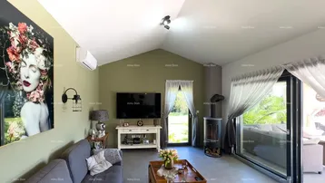 Gemütliches Wohnzimmer mit Kaminofen, bequemer Couch und Zugang zur Terrasse.