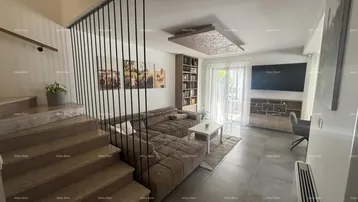 Modernes Wohnzimmer mit großem Ecksofa, Fliesenboden und offener Treppe zum Obergeschoss.