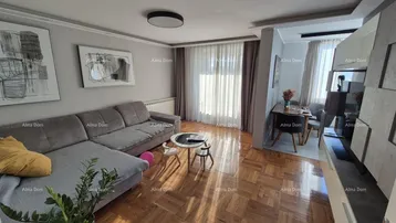 Helles Wohnzimmer mit bequemem Sofa, Parkettboden und angrenzendem Essbereich, ideal für entspannte Stunden.