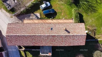 Luftaufnahme eines Hauses mit traditionellem Ziegeldach und umliegendem Grundstück mit Parkplätzen.