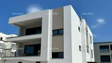Modernes Mehrfamilienhaus im Bau mit weißer Fassade und Balkonen unter blauem Himmel.