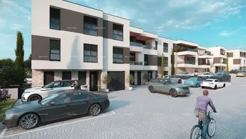 Moderne Wohnanlage mit Parkplätzen und gepflegter Außenanlage unter blauem Himmel.