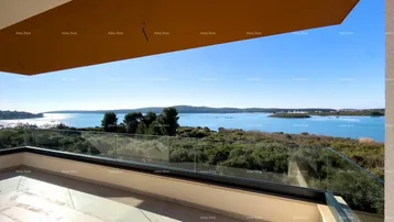 Geräumige Terrasse mit Glasgeländer und weitem Blick auf das Meer und die umliegende Landschaft.