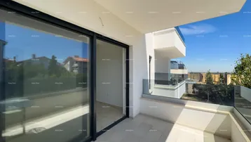 Heller Balkon mit Glasgeländer und Blick auf die Umgebung, ideal für entspannte Stunden im Freien.
