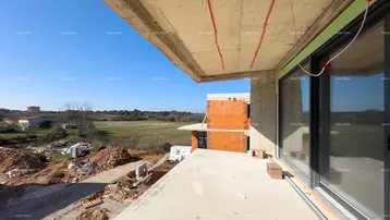 Unfertige Terrasse mit Blick auf die Baustelle und die umliegende Landschaft unter blauem Himmel.
