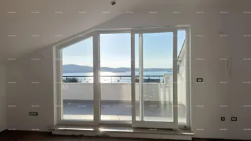 Heller Wohnbereich mit großen Schiebefenstern, Meerblick und Zugang zur Terrasse.