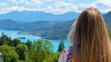Atemberaubender Blick auf einen türkisfarbenen See und majestätische Berge unter einem blauen Himmel.
