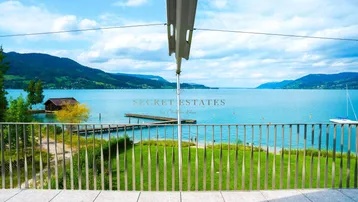 Weitläufige Terrasse mit Panoramablick auf den See, die Berge und den privaten Steg.