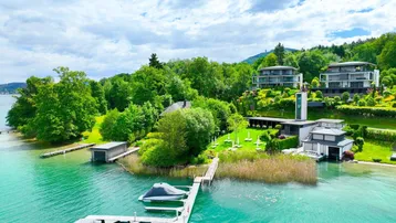 Spektakuläre Seeliegenschaft mit moderner Architektur, privaten Bootsanlegestellen und üppiger grüner Umgebung.