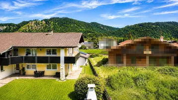 Rückansicht des Hauses mit Garten, Grillkamin und weitem Blick auf die umliegende Natur.
