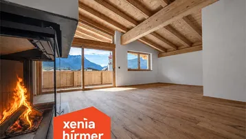 Geräumiges Wohnzimmer mit Holzbalkendecke, Kamin und Zugang zu einem Balkon mit Bergblick.