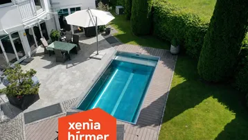 Gepflegter Gartenbereich mit modernem Pool, Holzdeck und gemütlicher Terrasse am Haus.