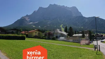 Panoramablick auf die majestätischen Berge und die umliegende Landschaft mit Häusern und Straße.