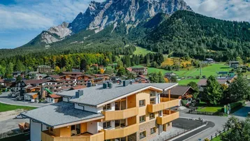 Beeindruckendes Mehrfamilienhaus in alpiner Architektur mit Blick auf die Zugspitze.