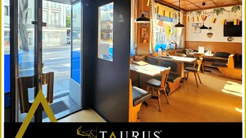 Eingangsbereich eines Restaurants mit Blick zur Straße und gemütlichem Essbereich im Hintergrund.