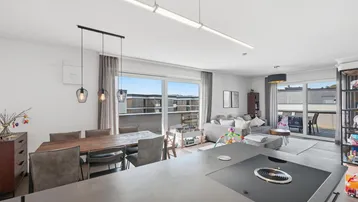 Moderne offene Küche mit Essbereich und Wohnzimmer, mit Zugang zur Terrasse.