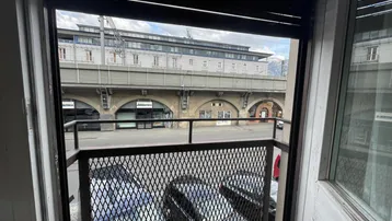 Blick von einem französischen Balkon auf die Straße und eine erhöhte Bahntrasse.