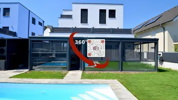 Modernes Haus mit Außenpool und überdachtem Bereich, umgeben von gepflegtem Rasen.