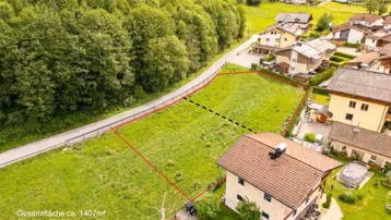 Luftaufnahme eines Hauses mit angrenzendem Grundstück, dessen Grenzen rot markiert sind.
