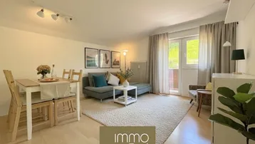 Heller Wohn- und Essbereich mit gemütlichem Sofa, Esstisch und Blick ins Grüne durch große Fenster.