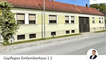 Gepflegtes Einfamilienhaus mit traditioneller Architektur und Ziegeldach von der Straße aus gesehen.