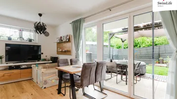 Helles Wohn- und Esszimmer mit Holzboden und direktem Zugang zur Terrasse.