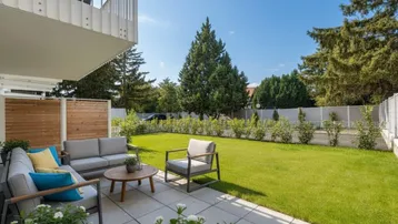 Geräumige Terrasse mit modernen Gartenmöbeln und direktem Zugang zum gepflegten Rasenbereich.