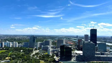 Panoramablick auf die Wiener Skyline mit modernen Hochhäusern und dem Donaukanal.