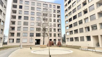 Außenansicht von modernen Wohngebäuden mit einem Gemeinschaftsbereich und Spielplatz.