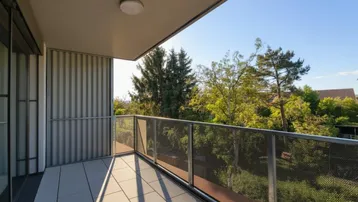 Moderner Balkon mit Fliesenboden und Blick ins Grüne unter blauem Himmel.