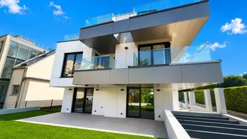 Moderne Architektur mit gestuften Terrassen, Balkonen und einem gepflegten Gartenbereich.