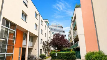 Innenhof einer modernen Wohnanlage mit gepflegten Grünflächen und Gebäuden.