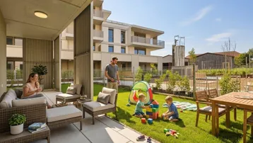 Sonnige Terrasse mit angrenzendem Garten und Spielbereich, ideal für Familien in einem modernen Wohnkomplex.