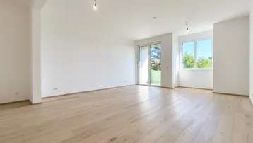 Helles Wohnzimmer mit neuem Parkettboden und Zugang zu einem sonnigen Außenbereich.