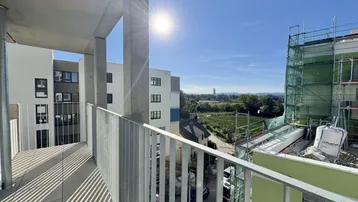 Heller Balkon mit Blick auf die Umgebung und angrenzende Weinberge, teilweise im Bau.