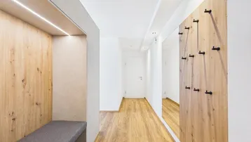 Heller Flur mit integrierter Sitzgelegenheit und Garderobe, die zu weiteren Räumen führt.
