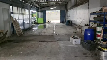 Große, leere Lagerhalle mit Betonboden und Wellblechdach, bereit zur Nutzung und vielseitig einsetzbar.