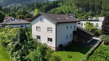 Freistehendes Haus mit Garten und Bergblick in einer grünen Umgebung.