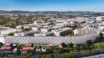 Luftaufnahme eines großen Wohnkomplexes in städtischer Umgebung mit umliegender Infrastruktur.