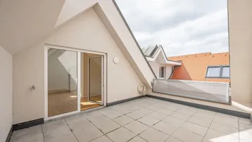 Geräumige Dachterrasse mit Fliesenboden und Blick auf die umliegenden Dächer.
