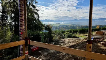 Blick von der Baustelle auf die malerische Berg- und Hügellandschaft in der Ferne.