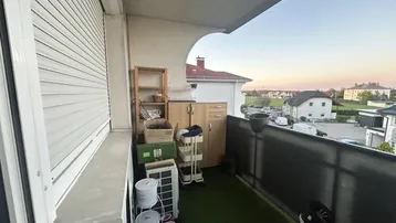 Balkon mit Kunstrasen, Stauraum und Blick auf die umliegende Wohngegend.
