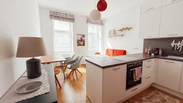 Helles Studio-Apartment mit integrierter moderner Küche und Essbereich.