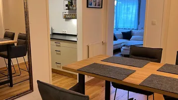 Moderner Essbereich mit Holzboden, der in die Küche und das Wohnzimmer übergeht.