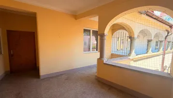 Überdachte Loggia mit Bögen und Blick auf den Innenhof, die einen geschützten Außenbereich bietet.