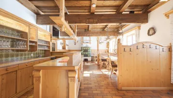Geräumiger Essbereich im traditionellen Stil mit Holzbalkendecke, Fliesenboden und einer Theke.