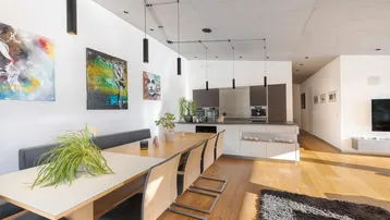 Moderner Essbereich mit Holztisch und integrierter Küche in hellem Design.