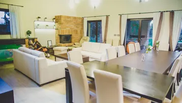 Geräumiger Wohn- und Essbereich mit gemütlichen Sofas, Kamin und großem Esstisch.